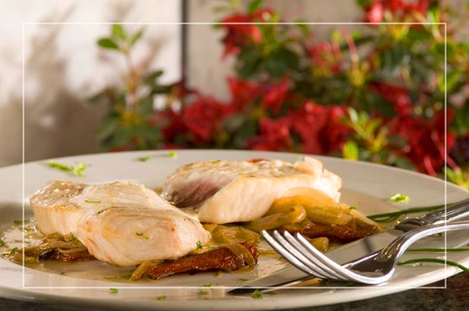 Delicious Italian chicken and steak dish plated on white plate and sitting on table in restaurant