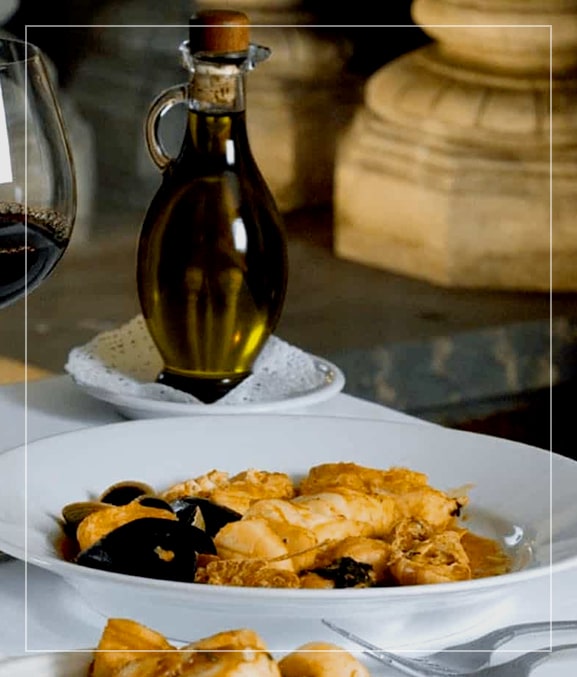 Italian dish sitting on table with bottle of olive oil